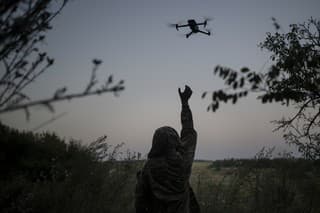 Na archívnej snímke z 19. augusta 2023 ukrajinský vojak sa naťahuje za dronom.