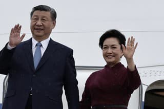 Čínsky prezident Si Ťin-pching a jeho manželka Pcheng Li-jüan mávajú na schodoch lietadla po pristátí na parížskom letisku Orly.