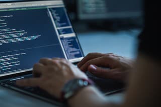 Close-up Focus on Person's Hands Typing on the Desktop Computer Keyboard. Screens Show Coding Language User Interface. Software Engineer Create Innovative e-Commerce App. Program Development