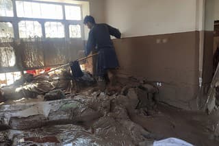 Muž zbiera svoje veci z poškodeného domu po silných záplavách v provincii Baglán na severe Afganistanu.