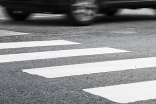 Pedestrian crossing road marking and fast moving car, photo with selective focus and shallow DOF
