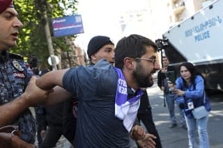 Policajti zadržujú demonštranta počas protivládneho protestu v Jerevane v nedeľu 25. mája 2024. 