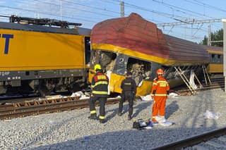 Na snímke hasiči stoja vedľa dvoch vlakov po zrážke v Pardubiciach 6. júna 2024.
