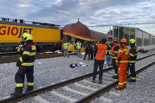 Na snímke hasiči stoja vedľa dvoch vlakov po zrážke v Pardubiciach 6. júna 2024.