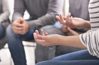 Emotional woman sharing her story during support session for addicts, close up on gesticulating hands