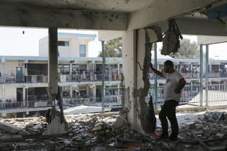 Palestínčania sa pozerajú na škody po izraelskom leteckom útoku na pásmo Gazy.