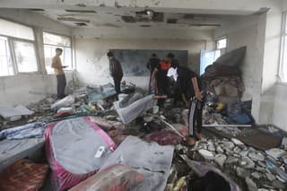 Palestínčania sa pozerajú na škody po izraelskom leteckom útoku na pásmo Gazy, kde bola zasiahnutá škola OSN, pri ktorom zahynulo niekoľko desiatok ľudí v palestínskom utečeneckom tábore Nusajrát 6. júna 2024.