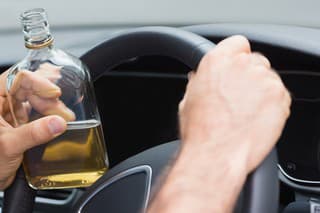Man drinking alcohol while driving in his car