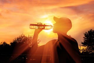 Silhouette of a man drinking water during heat wave