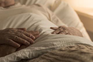Close-up of hand of senior on hand of dying elderly person as sign of support during sickness