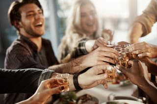 Shot of a group of young friends making a toast at a dinner party