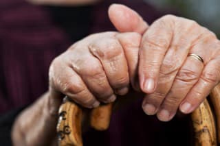 Close-up of senior woman's hands holding her walking sticks. Selective focus on hands and sticks.