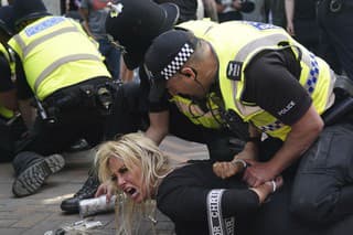 Policajti zadržujú ženu počas protestu v Nottinghame v sobotu 3. augusta 2024.