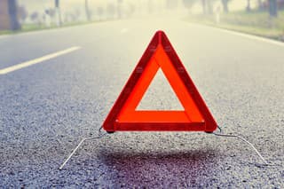 Bad weather driving - warning triangle on a misty road