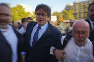 Katalánsky separatistický líder Carles Puigdemont (druhý zľava) a jeho právnik Gonzalo Boye (druhý sprava) prichádzajú pred dav  priaznivcov v Barcelone.