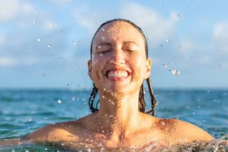 People happy and having fun in summer swimming activity in the ocean water.