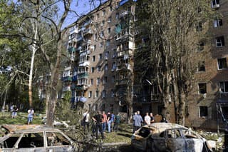 Obyvatelia stoja pred obytným domom po útoku ukrajinskej armády v meste Kursk na západe Ruska, ležiacom asi 120 až 150 km od hranice s Ukrajinou v nedeľu 11. augusta 2024.