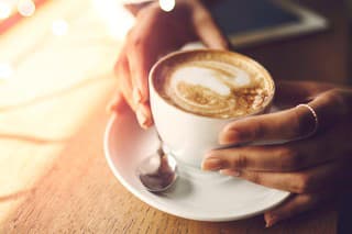 Closeup shot of an unrecognizable woman having a cup of coffee at a cafe