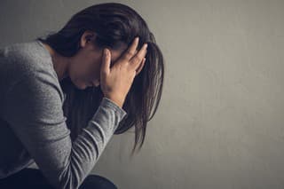 Depressed woman sitting on a chair in dark room at home. Lonly , sad, emotion concept.