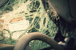 Close op of the steering wheel and shatterd windshield of a wrecked vehicle.  Cross processing.