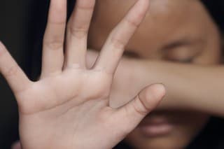 Little girl suffering bullying raises her palm asking to stop the violence