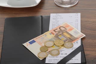 Close-up Of Bill With Euro Note On Wooden Table