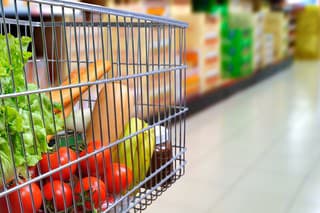 Shopping cart full of food in the supermarket aisle. Side tilt view. Horizontal composition