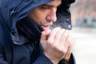 Man breathing on his hands to keep them warm