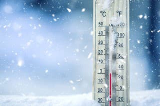 Thermometer on snow shows low temperatures - zero. Low temperatures in degrees Celsius and fahrenheit. Cold winter weather - zero celsius thirty two farenheit.