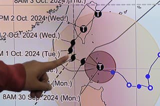 Odborníčka na počasie z filipínskeho Úradu pre atmosférické, geofyzikálne a astronomické služby Veronica Torresová ukazuje  smer silného tajfúnu Krathon na Filipínach v pondelok 30. septembra 2024.