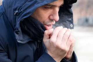 Man breathing on his hands to keep them warm