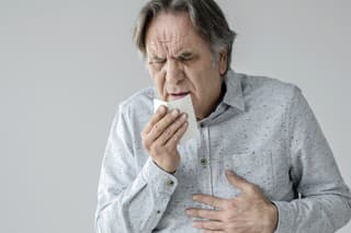 Old man coughing to tissue