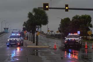 Polícia blokuje most vedúci na bariérový ostrov St. Pete Beach na Floride pred príchodom hurikánu Milton.