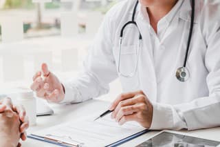 Doctors and patients consulting and diagnostic examining sit and talk. At the table near the window in the hospital medicine concept