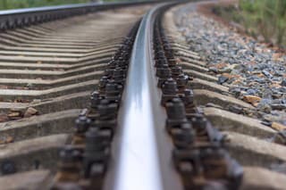 Railway rails and sleepers close-up. A railway that goes around a bend in the distance.