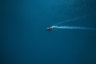 Aerial view of boat in the sea. Travel freedom concept. Shoot directly above