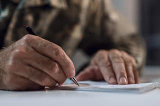 Close up of mature army soldier writing a letter.