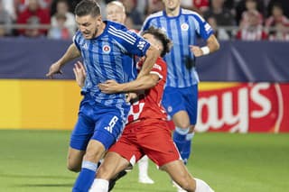 Na snímke Kevin Wimmer (vľavo) z ŠK Slovan Bratislava a Alejandro Frances (uprostred) z Girony bojujú o loptu. 