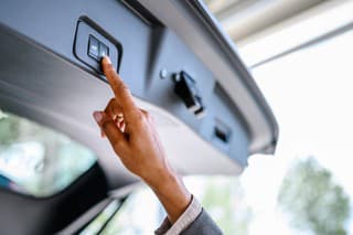 Woman presses the button to close the trunk of the car