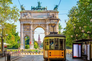 View of the Peace Arch with yellow tram in Milan, Italy