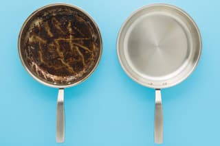 Dirty oily and clean stainless frying pans on light blue table background. Closeup. Pastel color. Removing burn grease stain. Compare two objects. Top down view.