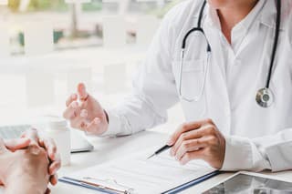 Doctors and patients consulting and diagnostic examining sit and talk. At the table near the window in the hospital medicine concept