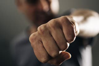 closeup of a young caucasian man throwing a punch to the observer, with a dramatic effect