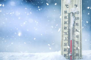 Thermometer on snow shows low temperatures - zero. Low temperatures in degrees Celsius and fahrenheit. Cold winter weather - zero celsius thirty two farenheit.