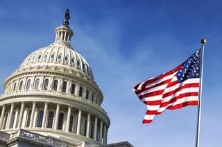 American flag waving with the Capitol Hill in the background