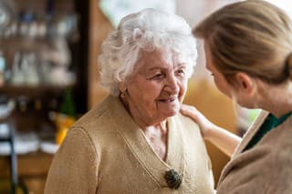 Health visitor talking to a senior woman during home visit