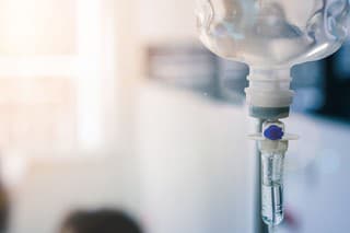 Healthcare concept, Close up of medical drip or IV drip chamber in patient room, Selective focus.