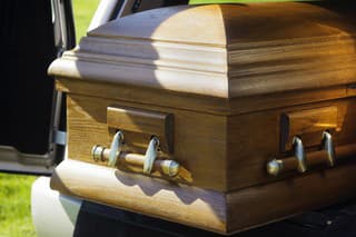 A casket in the back of an open hearse.