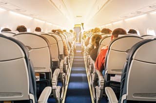 Commercial aircraft cabin with rows of seats down the aisle. morning light in the salon of the airliner. economy class