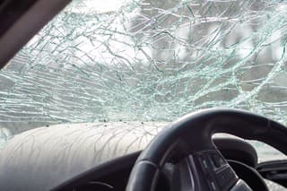 Damaged car window after an accident. Broken windshield as a result of an accident, inside view. Cabin interior details, view from the cab. Safe movement. Broken windshield. Glass crack and damage